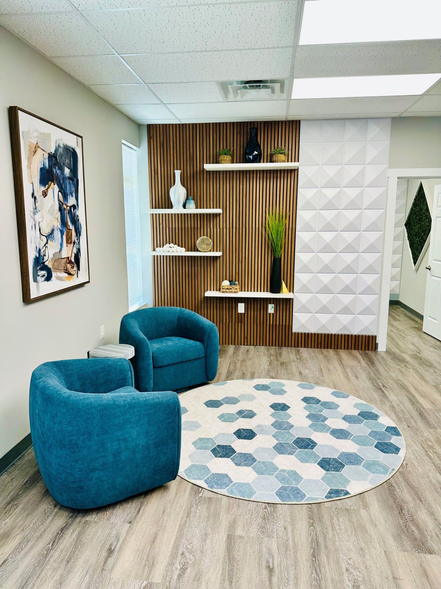 Patient lounge with teal accent chairs and warm wood detail at Infuse One Ohio